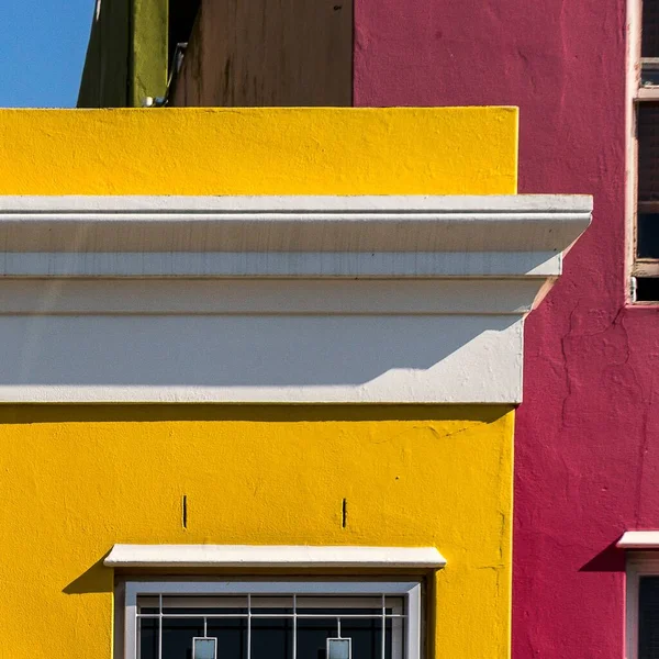 A closeup of colorful buildings under the sunlight and a blue sky at daytime in Cape Town