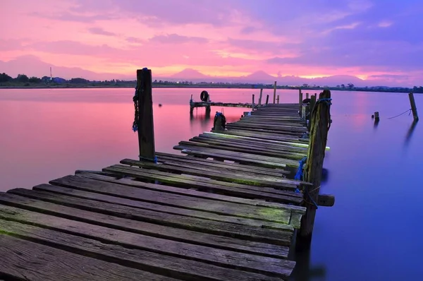 The mesmerizing view of the wooden pier near the calm lake during sunset