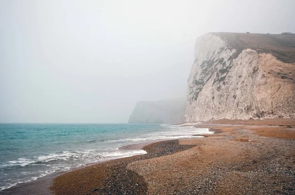 The mesmerizing view of the calm ocean on a foggy day in Purbeck Heritage Coast Swanage UK