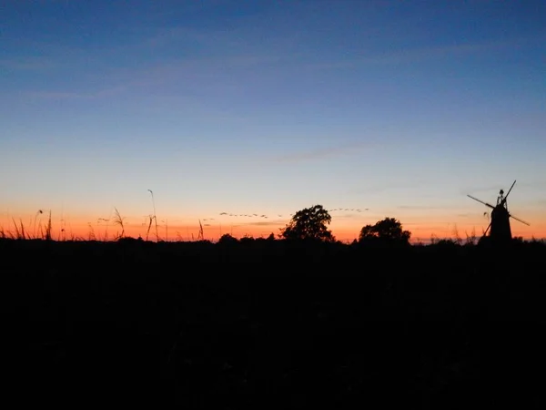 Uma Silhueta Moinho Vento Campo Com Cenário Pôr Sol Céu — Fotografia de Stock