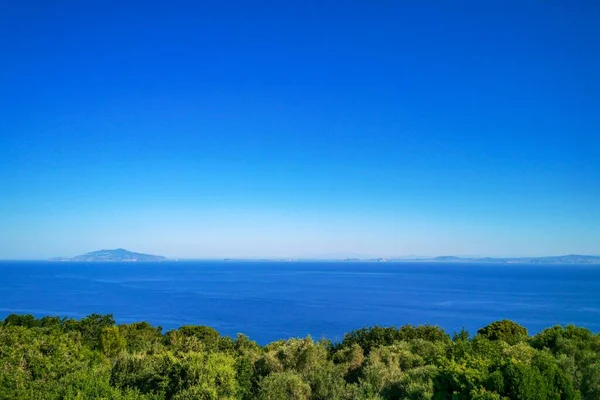 ナポリ湾とカンパニア州のイスキア島を背景に澄んだ青空が広がるイタリアのアナップリ島の美しい海 — ストック写真