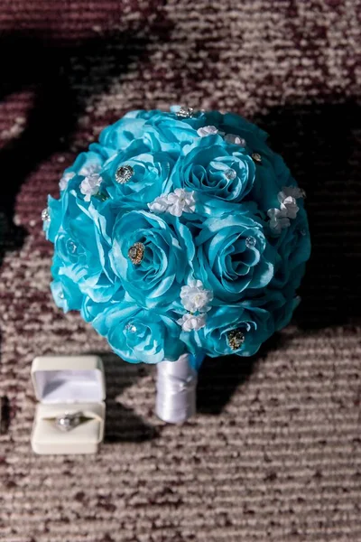 新娘的蓝绿色花束和戒指的一个垂直特写镜头 — 图库照片