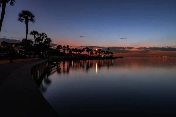 Silhouettes Buildings Palm Trees Surrounded Sea Sunset Evening — Stock Photo, Image