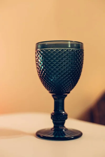 Masanın Üzerindeki Mavi Bir Bardağının Dikey Yakın Çekimi Işıkların Altında — Stok fotoğraf