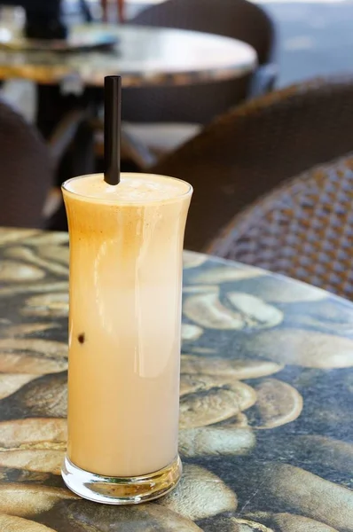 黒いわらでガラスカップの中に冷たい白いフレップコーヒーの垂直クローズアップショット — ストック写真
