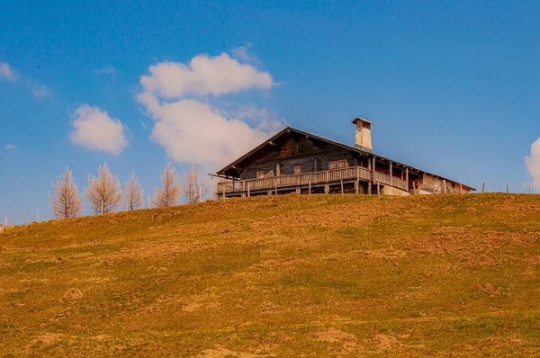 スイスのコリバリアのルアンで夏の日に青い空に対して丘の上に古い牧場の低角度ショット — ストック写真