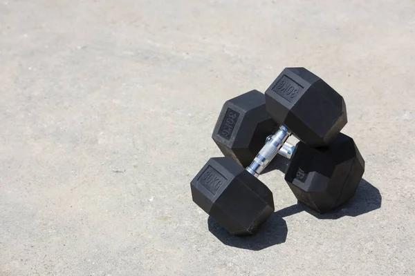 Closeup Shot Two Dumbbells One Placed Top Other Lying Ground — Stock Photo, Image