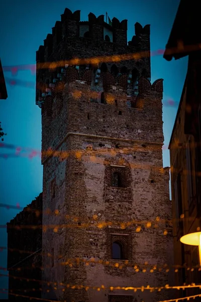 Ein Vertikales Bild Des Schlosses Scaligero Umgeben Von Lichtern Abend — Stockfoto