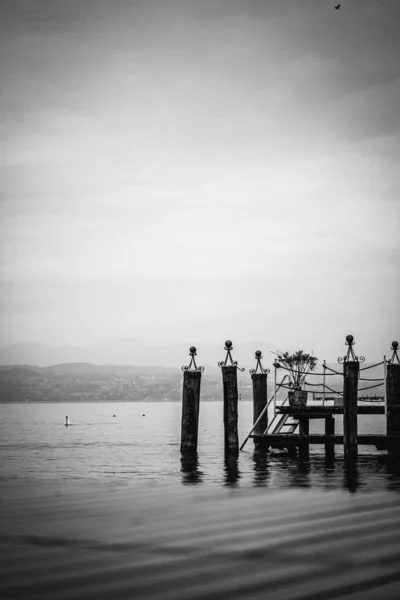 Greyscale Vertical Planks Wood Sea Surrounded Hills Covered Fog — Stock Photo, Image