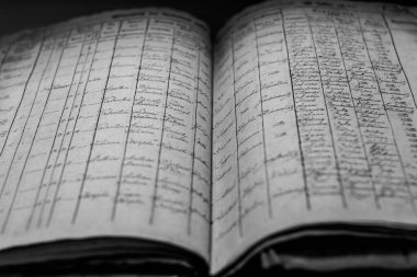 A closeup of an old book of local records with list of residents' names and information clipart