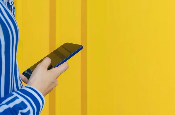 Female Blue Striped Shirt Texting Phone Standing Yellow Wall — Stock Photo, Image