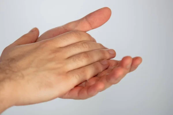 A closeup of rubbing hands with sanitizer on a white background, to prevent spread of coronavirus