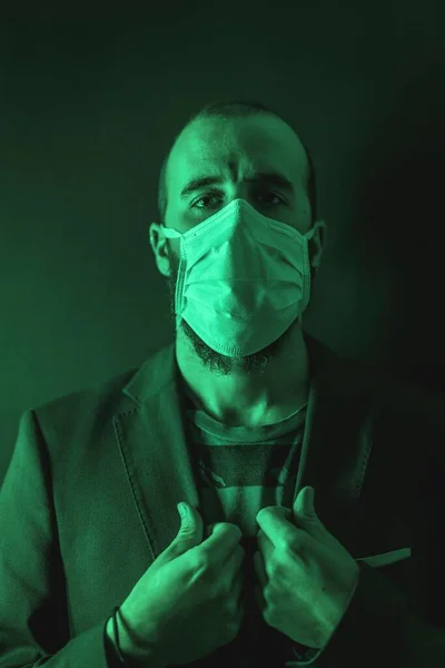 彼の概念のPfコロナウイルス上の緑の光と医療面マスクを身に着けている若い男 — ストック写真
