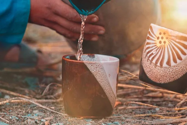 Primer Plano Mano Una Persona Vertiendo Agua Vaso Arcilla Suelo —  Fotos de Stock