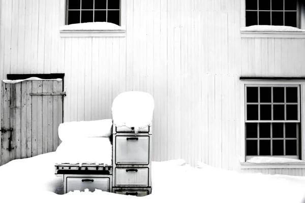 白雪公主 白雪公主白天在阳光下被雪覆盖的建筑物前的一个旧烤箱的灰白色鳞片 — 图库照片
