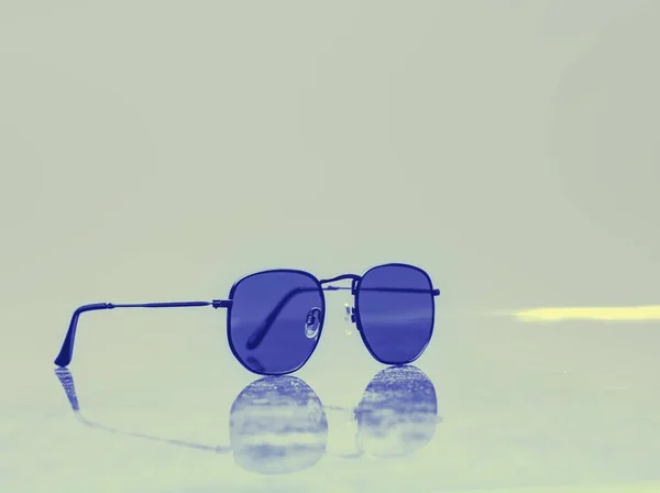 Zbliżenie Pary Niebieskich Okularów Przeciwsłonecznych Powierzchni Odblaskowej — Zdjęcie stockowe