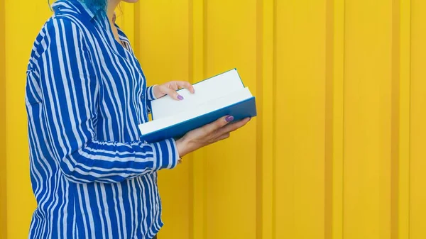 Uma Jovem Mulher Livro Leitura Camisa Azul Frente Uma Parede — Fotografia de Stock
