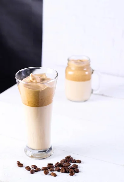 一杯垂直拍摄的两杯焦糖冰沙 相邻的是咖啡豆 — 图库照片