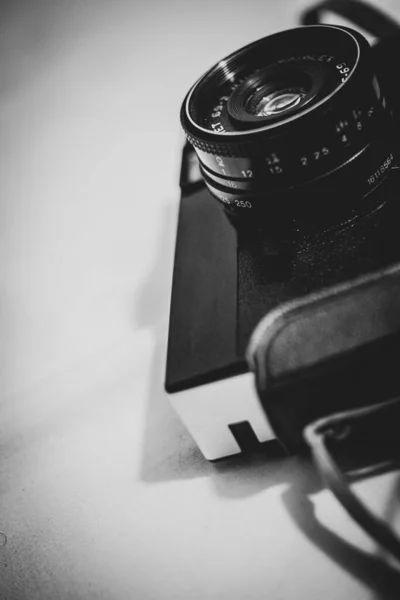 グレースケールでレンズに焦点を当てたフィルムカメラの垂直クローズアップ — ストック写真
