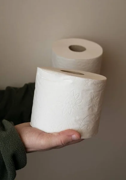 Vertikal Bild Två Toalettpapper Rullar Hålls Upp Människa Den Beige — Stockfoto