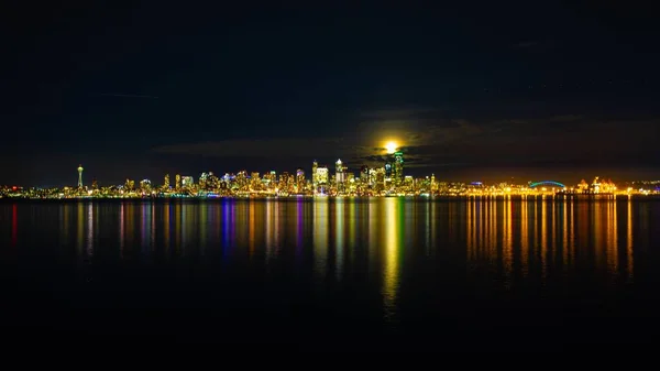 月の下の水に反射する都市の光の広い角度のショット — ストック写真