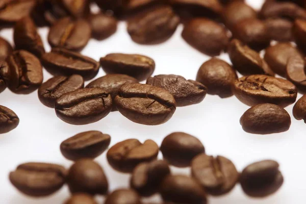 Beyaz Bir Yüzey Üzerinde Bir Sürü Kahve Çekirdeğinin Yakın Plan — Stok fotoğraf