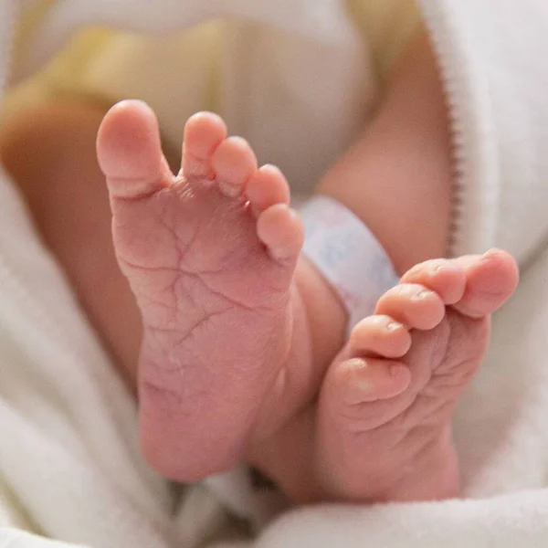 Vertical Closeup Feet Newborn Kid Lights Blurry Background — Stock Photo, Image