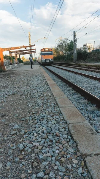 Высокоугольный Снимок Приближающегося Оранжевого Поезда Железнодорожной Станции — стоковое фото