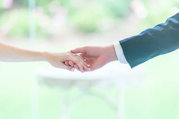 Closeup Selective Focus Shot Groom Bride Holding Hands Greenery Background — Stock Photo, Image