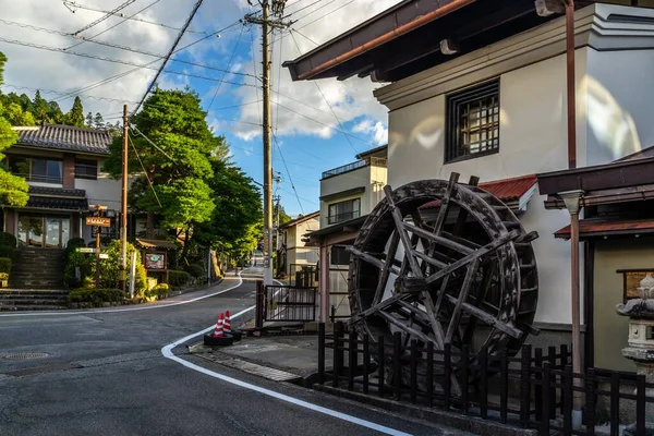 日本高山市一座被阳光下的建筑物环绕的老水磨坊 — 图库照片