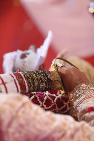 照明の下でインドの結婚式の間に剣を運ぶ新郎の垂直方向の高角度 — ストック写真