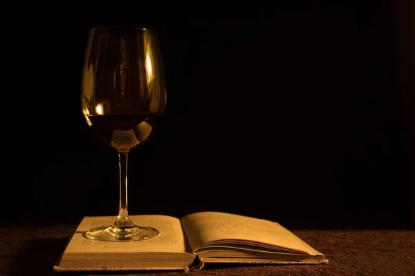 一杯红酒和黑色底色的书 — 图库照片
