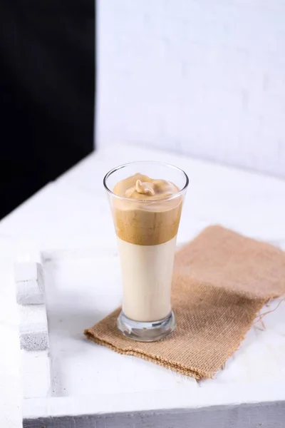 Ένα Ποτήρι Smoothie Καραμέλα Ένα Καφέ Ρούχο Δίπλα Μια Λευκή — Φωτογραφία Αρχείου