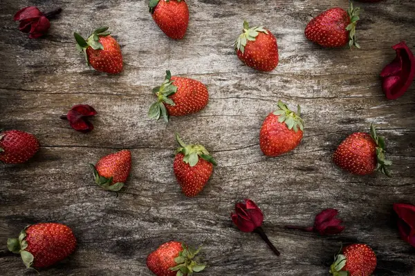 Disparo Alto Ángulo Fresas Frescas Pétalos Flores Rojas Una Superficie — Foto de Stock