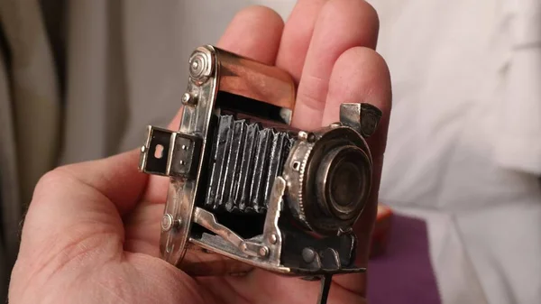 Işıkların Altında Küçük Metal Bir Kamera Figürü Tutan Kişinin Seçici — Stok fotoğraf