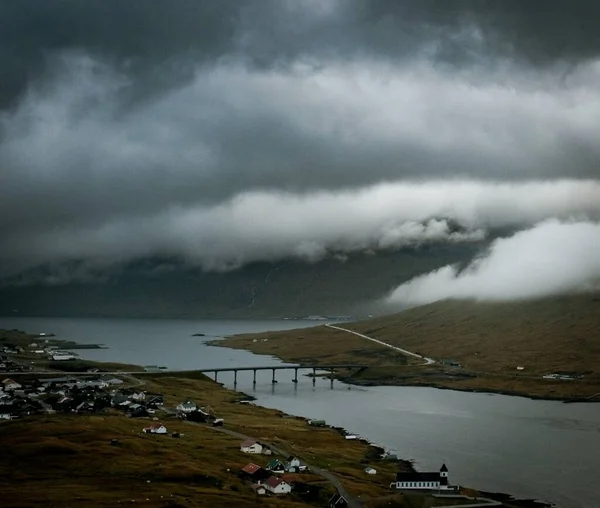 フェロー諸島の美しい自然を捉えたショット 橋の山 重い雲による町 — ストック写真
