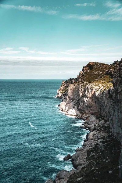 岩の多い海岸と青い穏やかな海の美しい垂直ショット — ストック写真