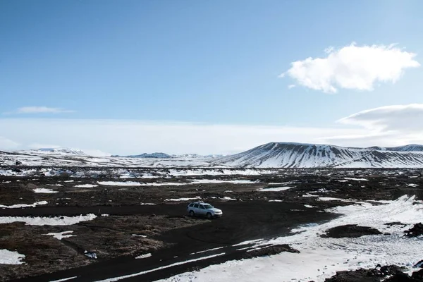 Piękne Ujęcie Srebrnego Samochodu Polu Pełnym Wzgórz Pokrytych Śniegiem — Zdjęcie stockowe