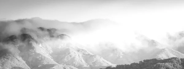 Szary Kadr Pięknych Szczytów Gór Ledwo Widoczny Przez Mgłę — Zdjęcie stockowe
