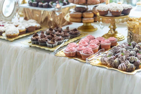 テーブルの上の金色のトレイにおいしいカップケーキやお菓子の高角度ショット — ストック写真