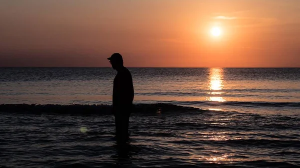 令人惊奇的是 在日落的背景下 一个人物形象站在海滩上 — 图库照片