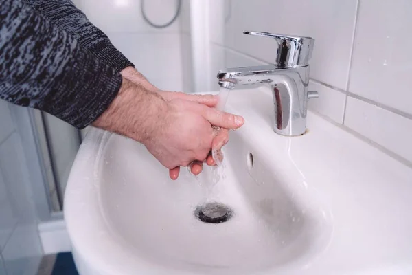 欧洲男人在明亮的浴室里洗手 定期洗手可减少感染病毒和感染的风险 — 图库照片
