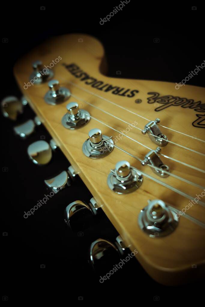 NOTTINGHAM, UNITED KINGDOM - Mar 23, 2020: Close up of fender Stratocaster electric guitar headstock and tuning pegs with 6 strings and fender logo visible