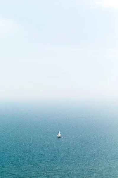 Disparo Vertical Una Vela Mar Azul Con Cielo Blanco — Foto de Stock