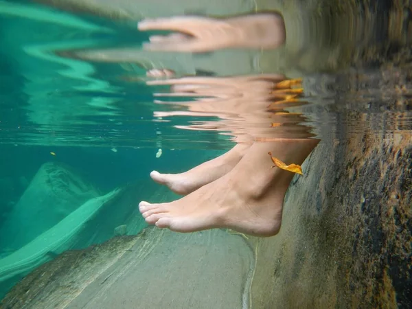 An underwater photo of feet soaked in water at the a river
