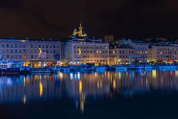 The Marseille old port at night with the basilica of Notre Dame de la Garde in the background France