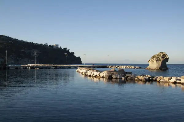 桟橋の隣にある湖畔に建てられた岩壁 — ストック写真