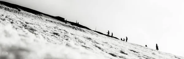 Grayscale Panoramic Shot Snowy Hillside Pith Lots Walking People Silhouette — Stock Photo, Image