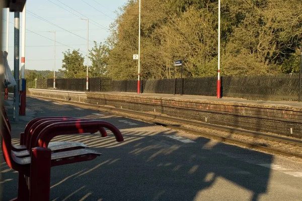 イギリスの鉄道駅の赤いベンチ — ストック写真