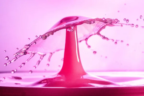 Tapiz Una Fresca Salpicadura Agua Rosa Sobre Fondo Borroso Ideal —  Fotos de Stock